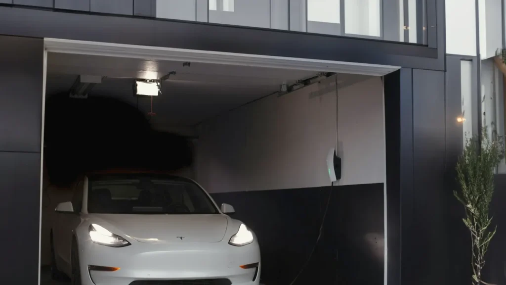 Hvid elbil i en åben garage om aftenen